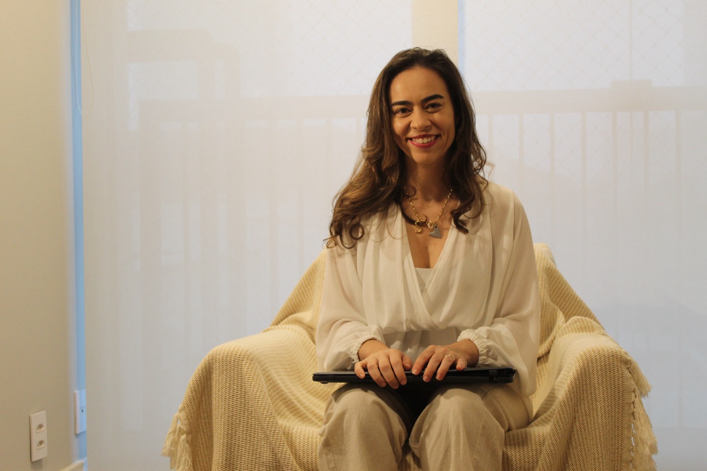 Simone de Siqueira com o notebook, pronta para uma sessão online